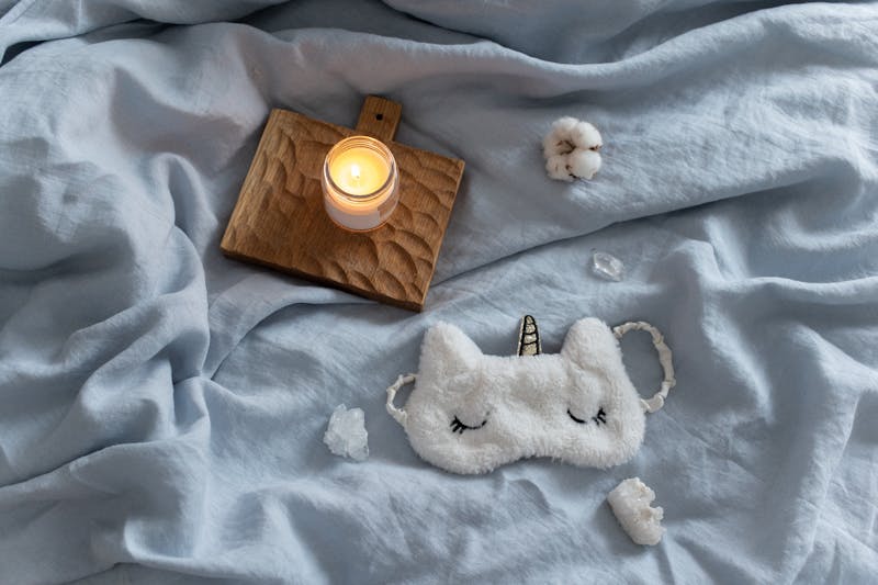 A lit candle and soft blanket creating a warm, comforting atmosphere for someone grieving
